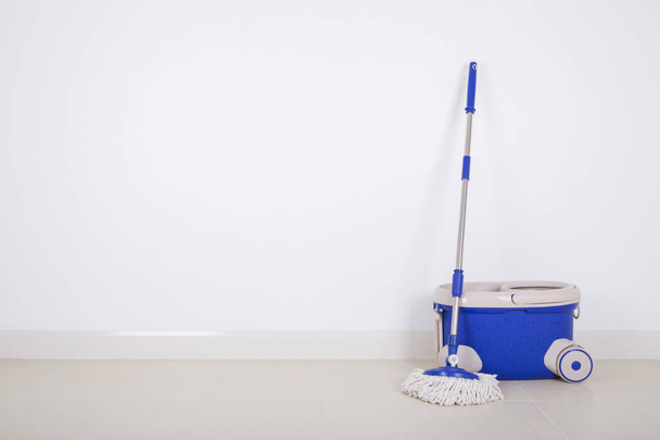 mop and blue bucket on floor and wall background - 写真・画像