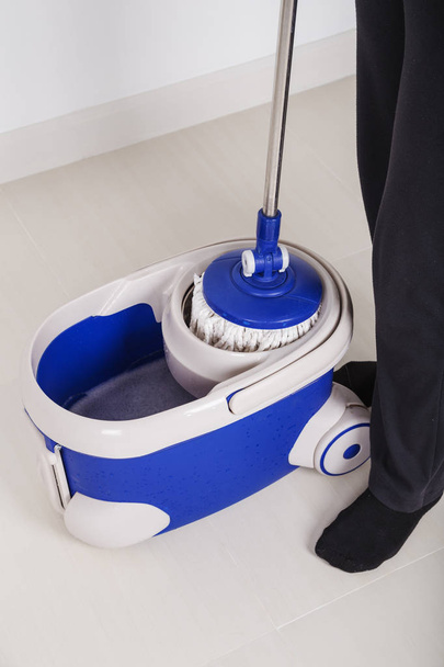 woman legs with mop and bucket cleaning floor - Foto, Imagen