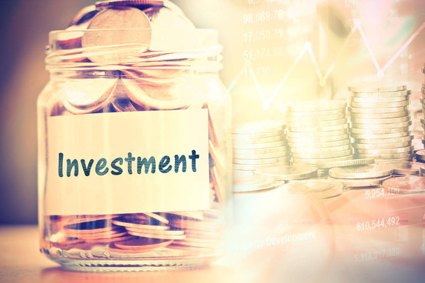 Munten in glazen pot met investeringen label voor geldbesparende financ - Foto, afbeelding