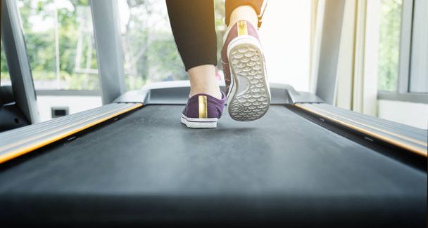 Close up woman in black sportswear running on treadmill machine  - Foto, immagini