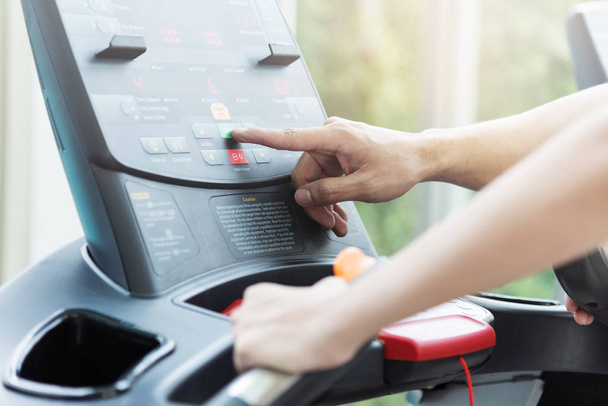 Close up personal trainer hands and woman hands using treadmill  - Foto, Imagen
