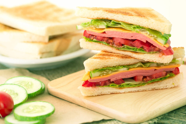 Pan rebanado de sándwiches a la parrilla con tocino, jamón y queso con
 - Foto, Imagen