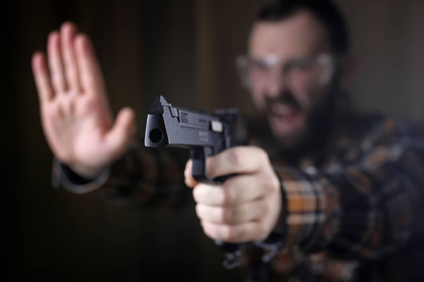 Mann mit Schutzbrille und Gehörbildung in Pistole - Foto, Bild
