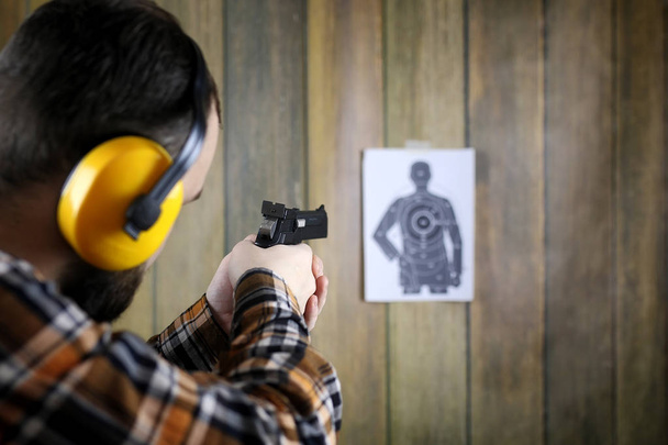 man met put op beschermende bril en oor opleiding in pistool sh - Foto, afbeelding