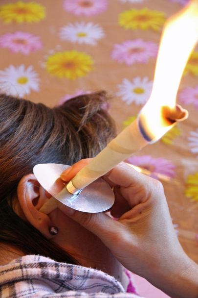 молодая женщина использует восковые шишки для чистки ушного воска
 - Фото, изображение
