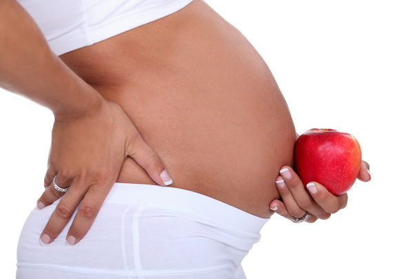 Pregnant woman holding an apple - 写真・画像
