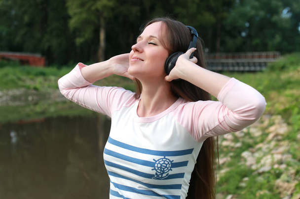 dívka poslouchat hudbu do sluchátek venkovní - Fotografie, Obrázek