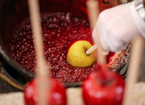 Cook el ile eldiven ve Kırmızı elma karamelize şeker - Fotoğraf, Görsel