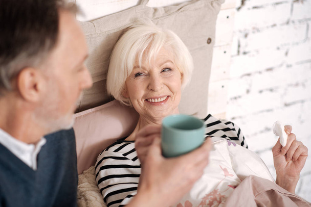 Closeup of senior lady taking tea from her husband - Zdjęcie, obraz
