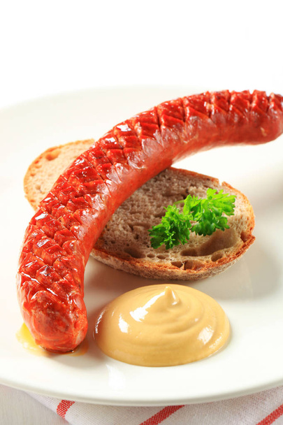 Salchicha húngara con pan y mostaza
 - Foto, imagen
