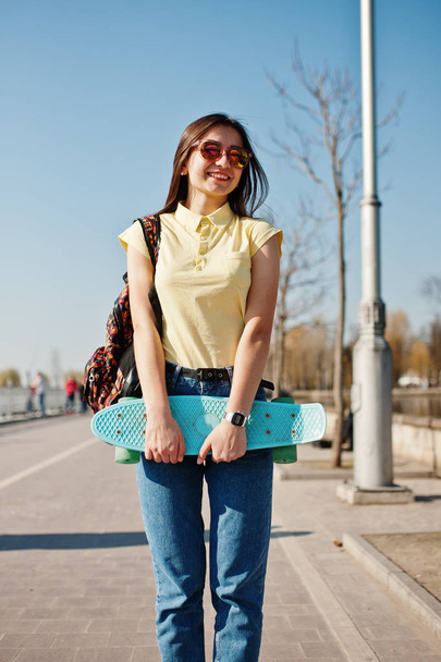 Young teenage girl with small skateboard, penny board, wear on y - Фото, изображение
