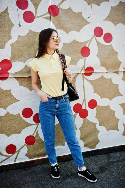 Young teenage girl against printed wall, wear on yellow t-shirt, - Valokuva, kuva