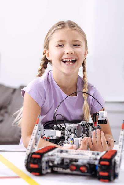 Smiling girl creating electronic robot at school - 写真・画像