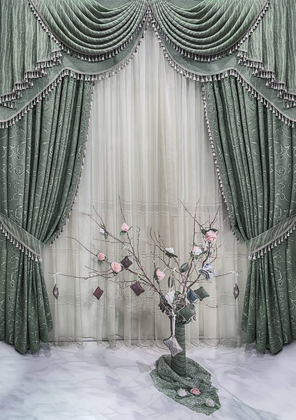 Роскошное оформление окон и стен в классическом стиле. Зеленые занавески с растительным рисунком, пелметом и тюлем
. - Фото, изображение