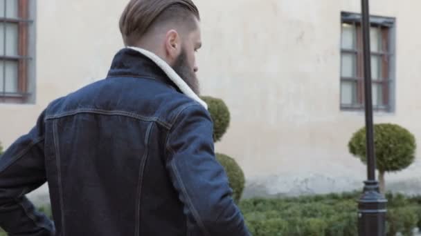 Portrait of bearded male with long hair dressed in a denim jacket, - Footage, Video