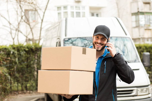 delivery man with cardboard in hands - Fotoğraf, Görsel