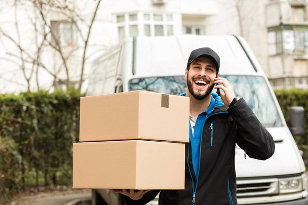 delivery man with cardboard in hands - Foto, imagen