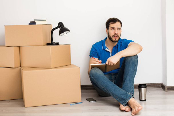man lying on the floor with packing boxes  - Photo, Image