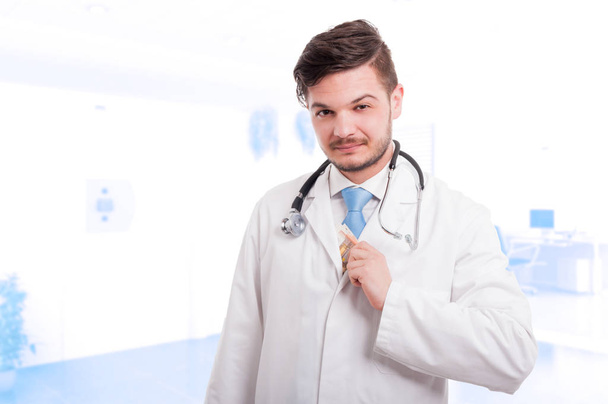 Knappe dokter om geld in zijn jas - Foto, afbeelding