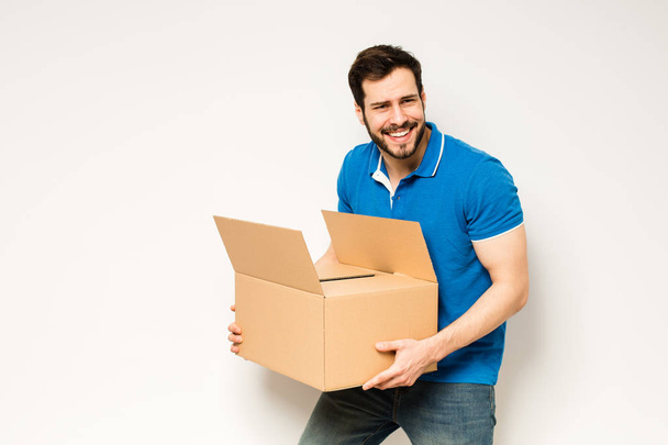 young man with a cardboard box in his arms - Fotoğraf, Görsel