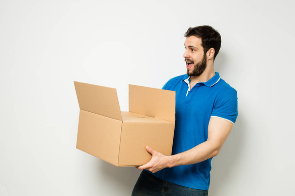 young man with a cardboard box in his arms - Foto, immagini