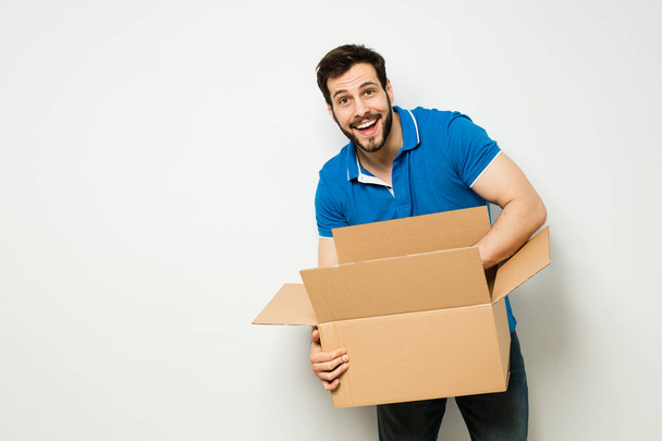 young man with a cardboard box in his arms - Foto, Imagen