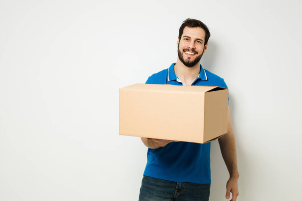 young man with a cardboard box in his arms - Foto, afbeelding