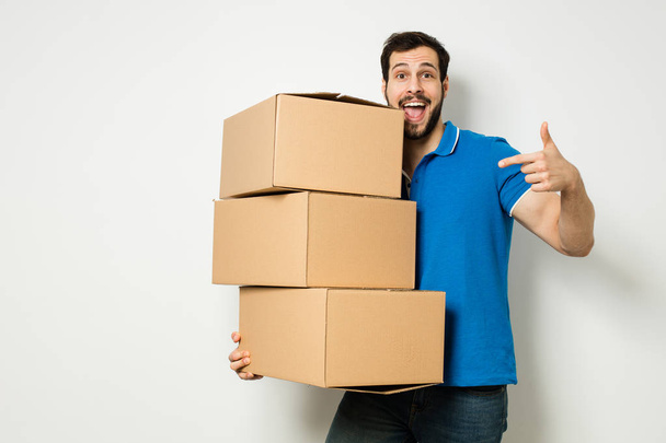 young man with a cardboard box in his arms - Фото, зображення
