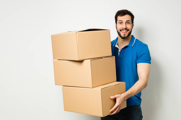 young man with a cardboard box in his arms - Φωτογραφία, εικόνα