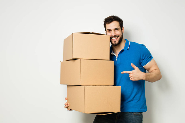 young man with a cardboard box in his arms - Foto, Bild