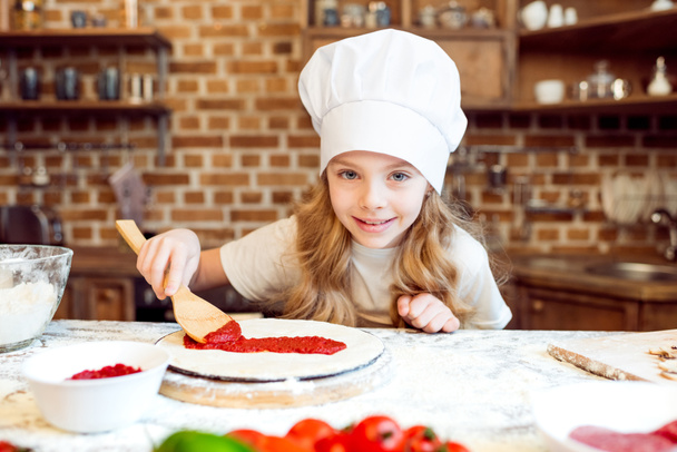girl putting sauce on dough - Foto, immagini