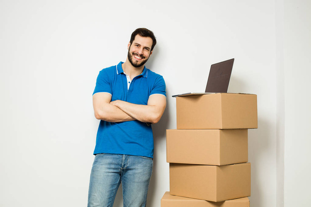 young man with a cardboard box in his arms - Φωτογραφία, εικόνα