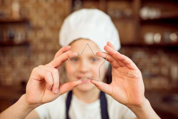 мальчик держит нож для печенья
  - Фото, изображение