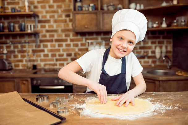boy making shaped cookies - Fotó, kép