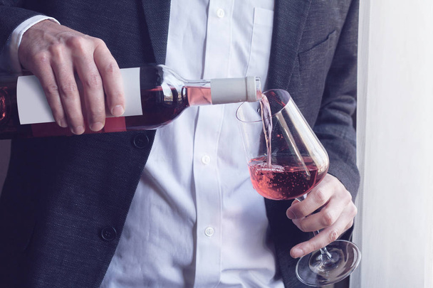 Uomo versando vino rosato in un bicchiere
 - Foto, immagini