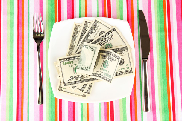 Banknotes on the plate on striped tablecloth close-up - 写真・画像