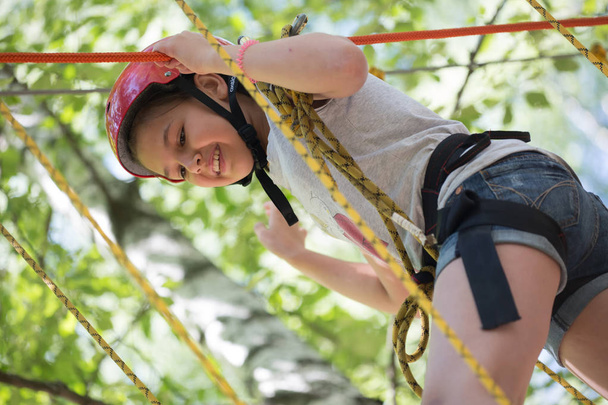 Tienermeisje in een helm op de touwen. Kinder Camping "Berezka". Redactie. Rusland. Yaroslavl regio. 17.07. 2016 - Foto, afbeelding