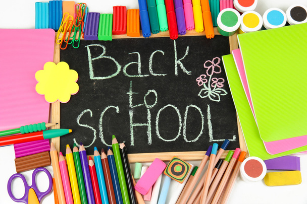The words 'Back to School' written in chalk on the small school desk with various school supplies close-up - Photo, Image