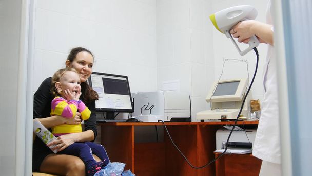 Enfant - petite fille - patiente en salle d'ophtalmologie - enfant avec maman à la consultation
 - Photo, image