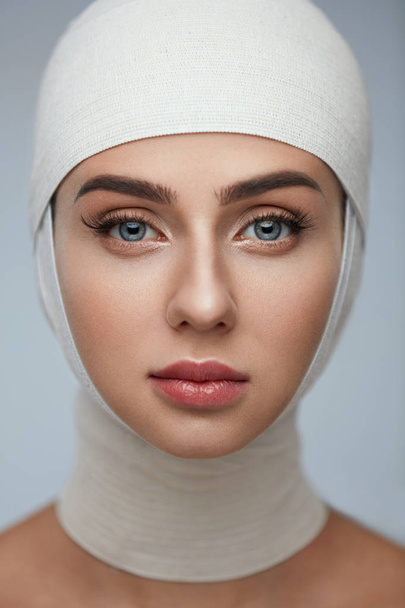 Woman Face With Smooth Soft Skin And Perfect Makeup In Bandages - Foto, Imagem