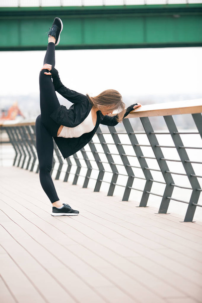 Fit fitness woman doing stretching exercises outdoors - 写真・画像