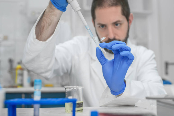Scientifique remplissant les éprouvettes avec une pipette en laboratoire
 - Photo, image
