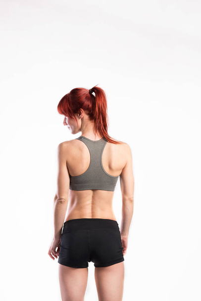 Attractive young fitness woman in sports bra. Studio shot. - Photo, image