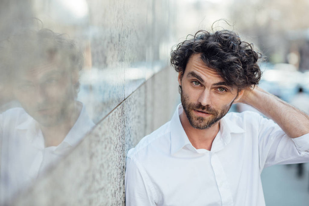 handsome elegant man stanting outside against a gray wall - Fotoğraf, Görsel