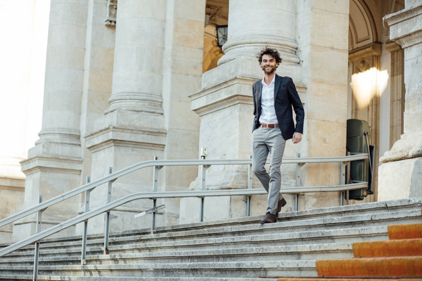handsome elegant man descending stairs of a building - Foto, Imagen