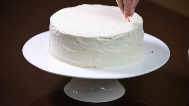女性の手には、ケーキが飾られています。赤いビロードのケーキ - 映像、動画