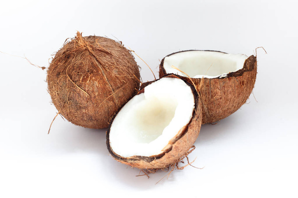 Kypsät kookospähkinät ja puolikookos valkoisella pohjalla
 - Valokuva, kuva