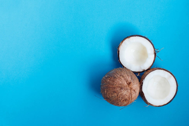Ripe coconuts and half coconut on blue background - Foto, immagini