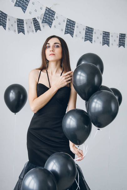 Girl in a black dress with black balloons - Foto, Imagem