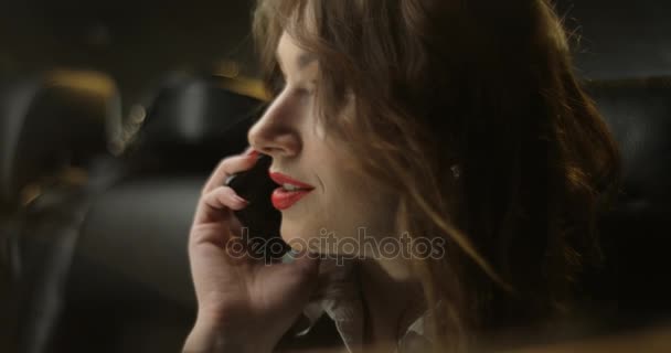 Answering and calling phone brunette through car window at night - Felvétel, videó